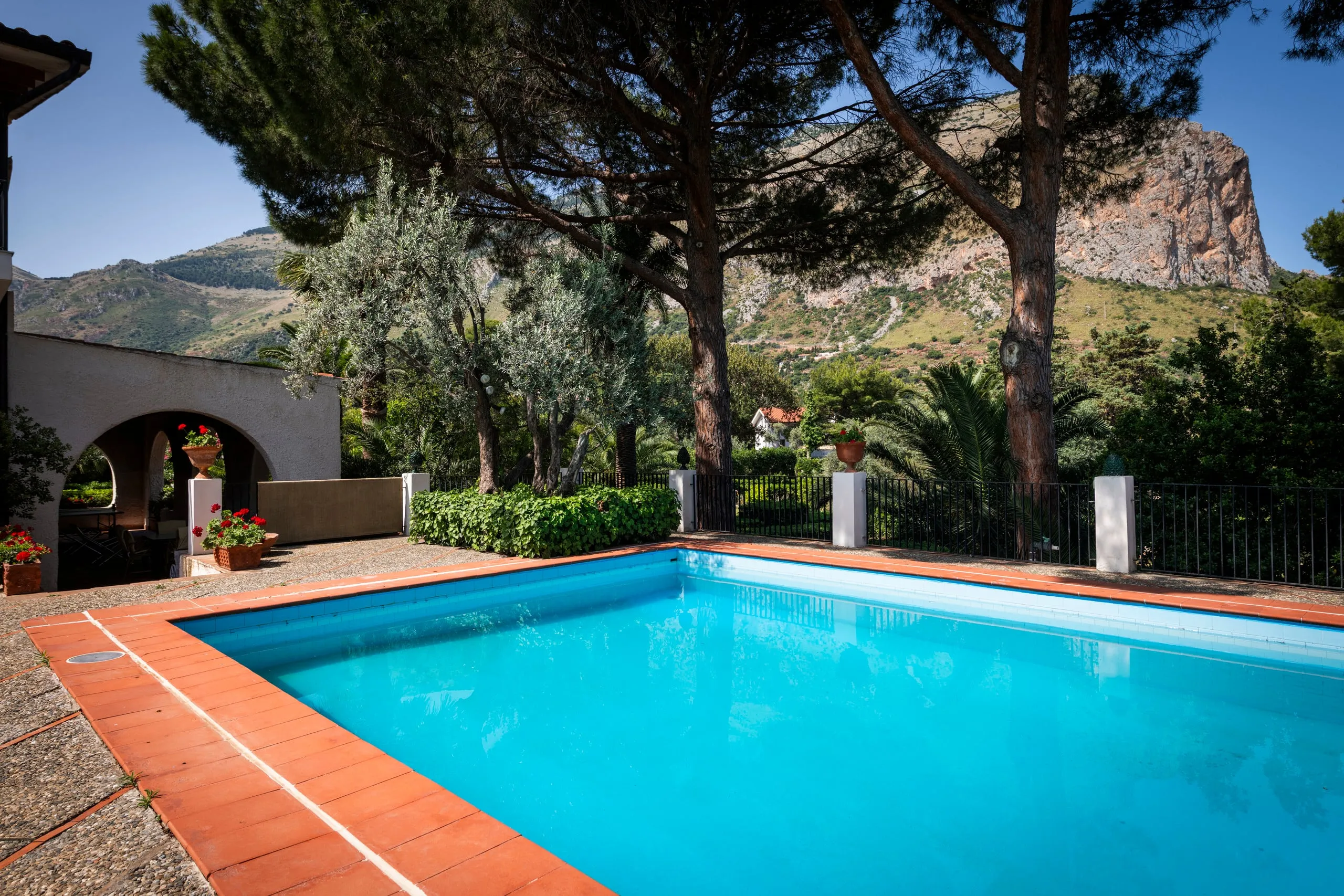 Piscina privata con vista sulla montagna rocciosa e pini mediterranei