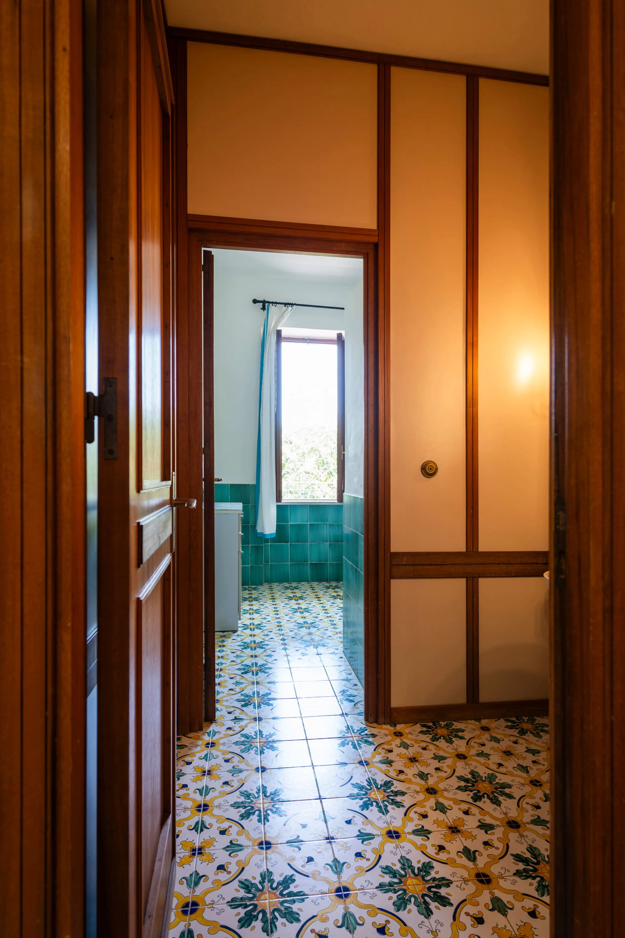 Bagno con piastrelle verdi e pavimento in maioliche siciliane decorate